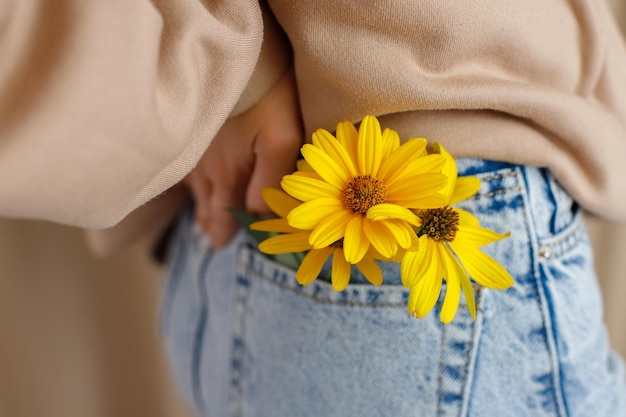 Photo yellow flowers in jeans pocket