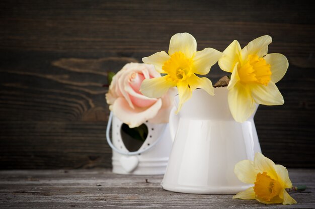 Yellow flowers in vase on wooden table