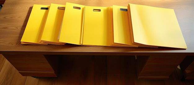 Yellow folders containing documents arranged on a wooden table seen from above There is open