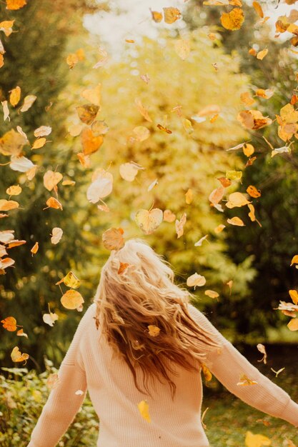 Photo yellow foliage in the girls shirts happy girl with leaves