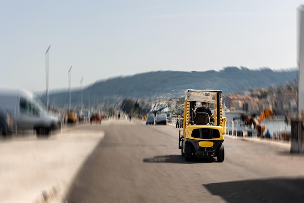 Foto macchina di sollevatore a forchetta gialla che lavora nel porto vista da dietro