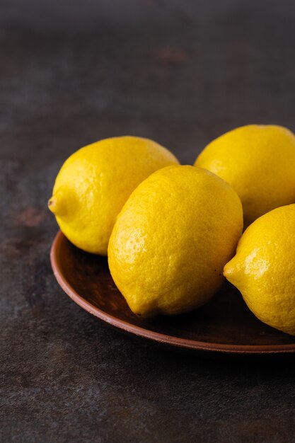 Yellow fragrant lemons on a dark table