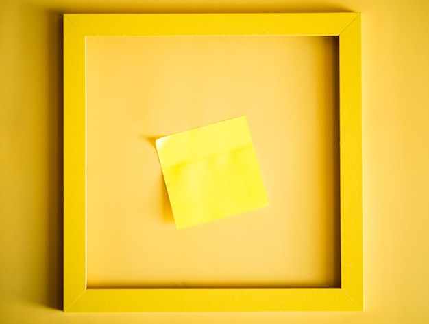 Yellow frame with blank yellow sticker for notes on yellow background