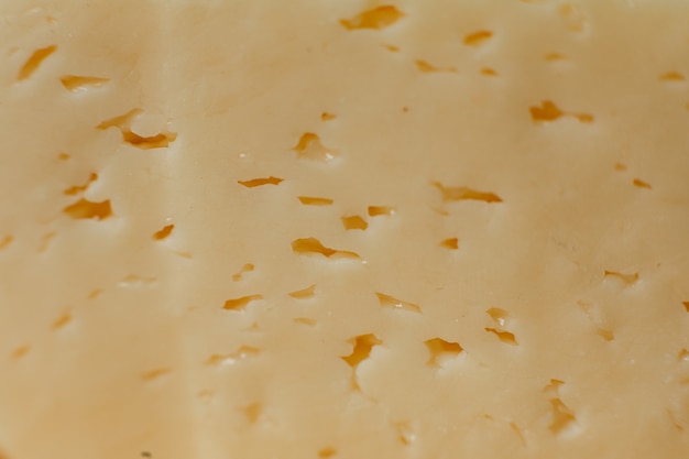 Yellow, fresh cheese with holes, wallpaper Cheese in the form of texture, background