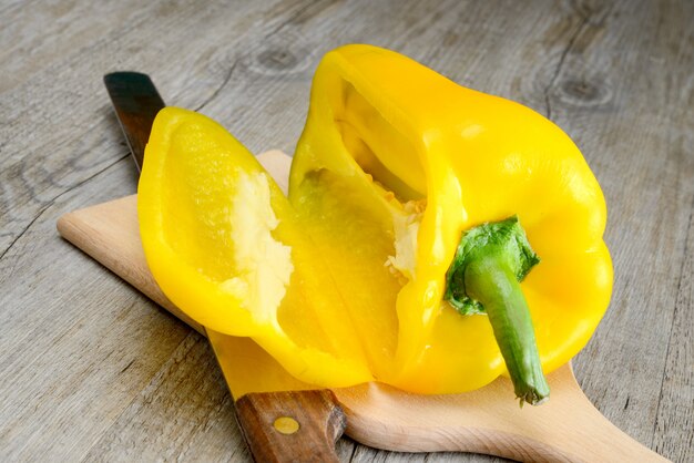 Yellow fresh pepper sliced on wooden surface