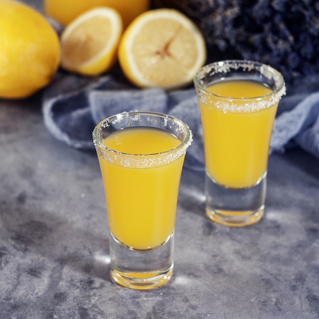 Yellow fresh shot cocktail or lemonade with lemon