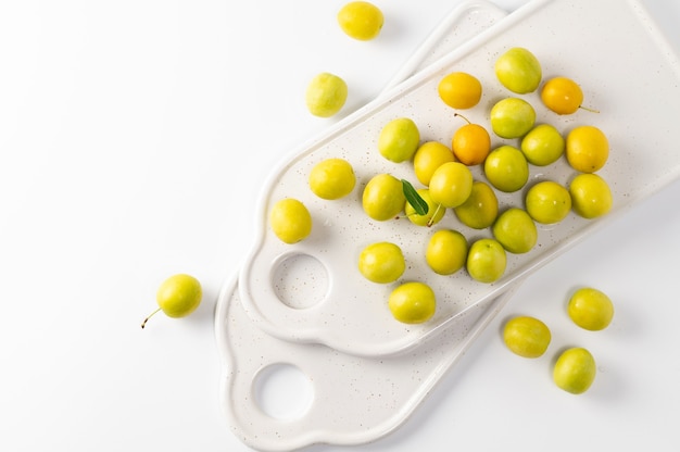 Photo yellow freshly torn cherry plum on a white background, top view