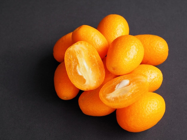 Yellow fruits of kumquat or cumquat on black background