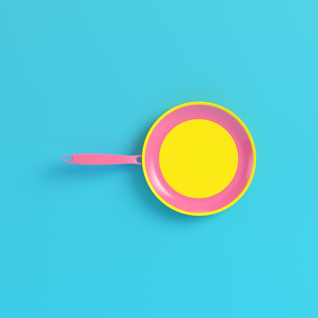 Yellow frying pan on bright blue background