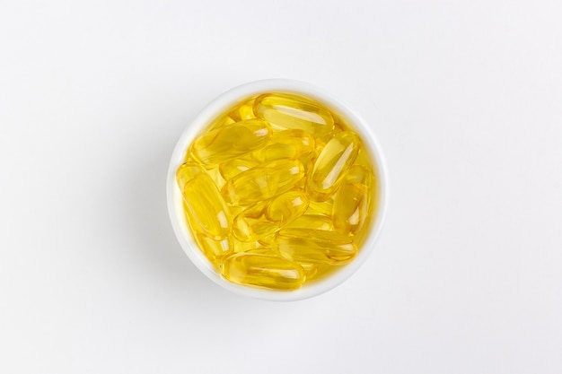 yellow gel fish oil pills on white background