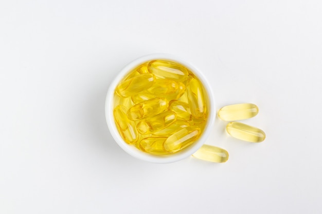 yellow gel fish oil pills on white background