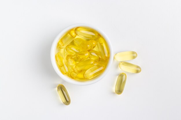 yellow gel fish oil pills on white background