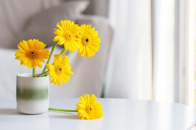 yellow gerbera in ceramic vase in light living room