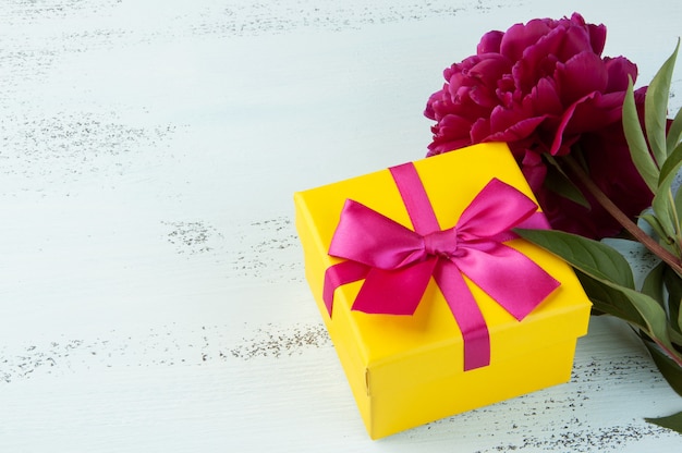 Yellow gift box with bow and peony