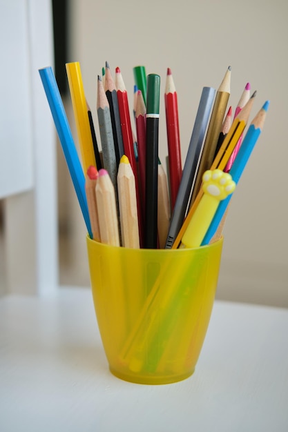 Yellow glass with colored pencils and funny pens High quality photo