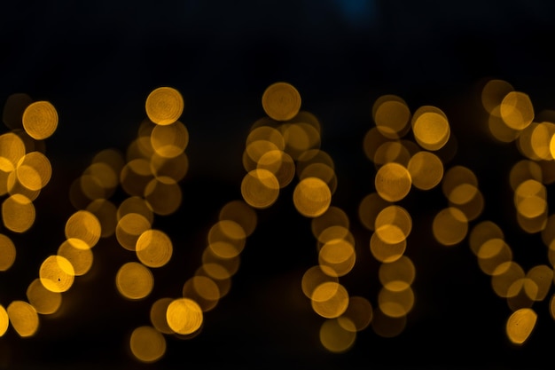 Yellow glitter vintage lights with black background Defocused