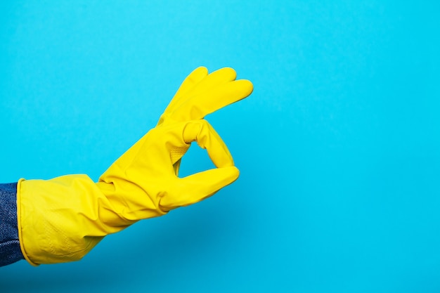 Yellow glove for cleaning on woman arm.