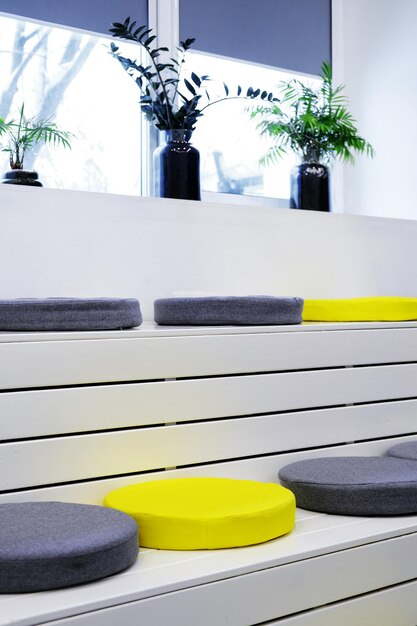 Yellow and gray soft seats on white wooden steps in the event space