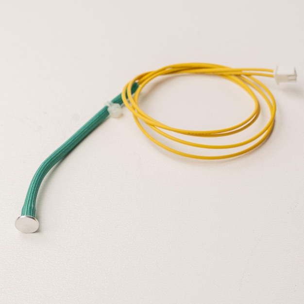 A yellow and green cord with a white wire attached to it.