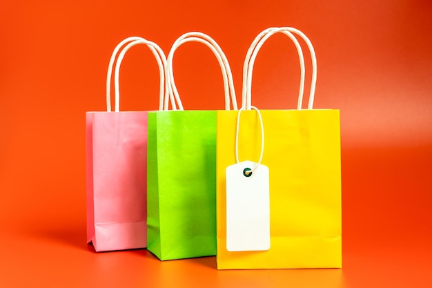 Yellow green and pink shopping or gift bags isolated on red