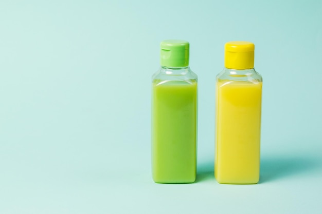 Yellow and green plastic bottles on a blue background