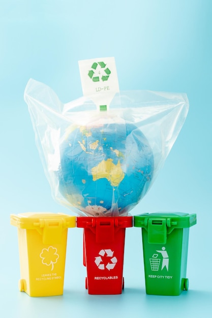 Yellow, green and red recycle bins with recycle symbol on blue background. Keep city tidy, Leaves the recycling symbol. Nature protection concept.