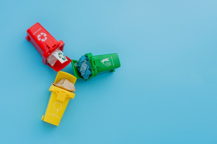 Photo yellow, green and red recycle bins with recycle symbol on blue background. keep city tidy, leaves the recycling symbol. nature protection concept