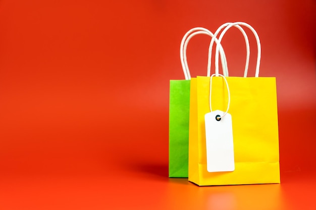 Yellow and green shopping or gift bags isolated on red