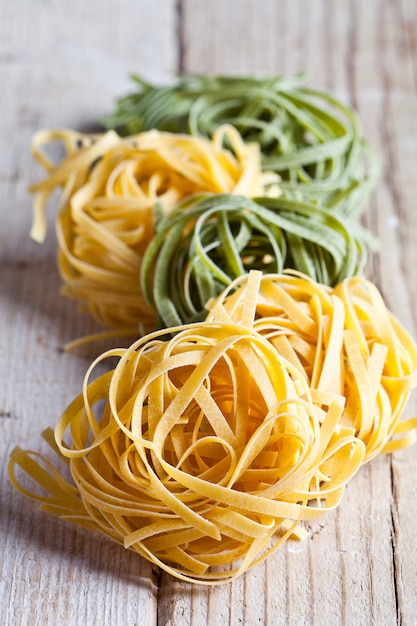 Yellow and green uncooked pasta tagliatelle