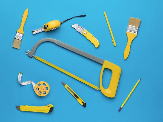写真 創造性のための明るい青色の背景に黄色の手工具修理と建設の概念フラットレイ