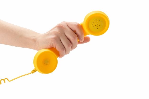 Microtelefono giallo in mano della donna isolata su bianco.