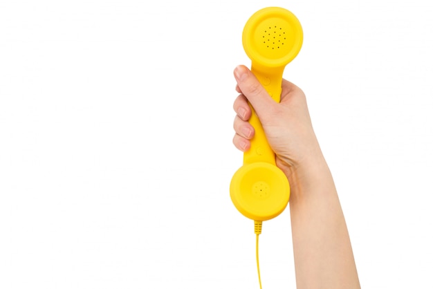 Yellow handset in woman hand isolated on white.