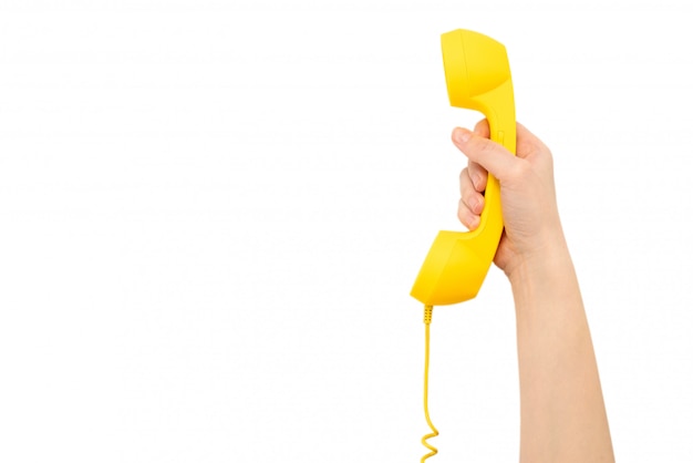 Yellow handset in woman hand isolated on white.