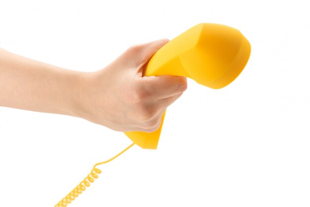 Yellow handset in woman hand isolated on white.