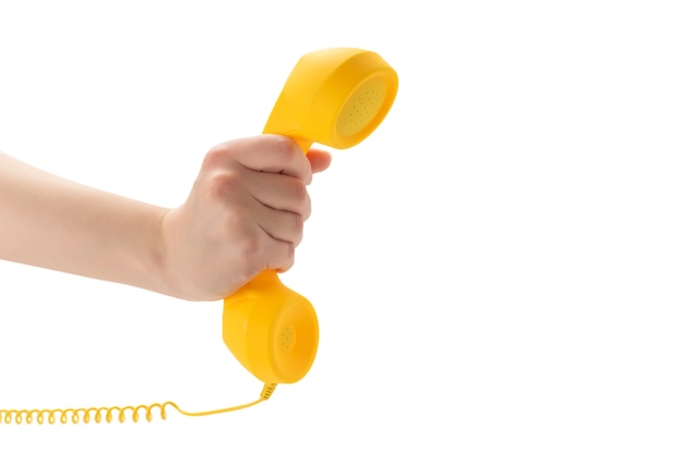 Microtelefono giallo in mano della donna isolata su bianco