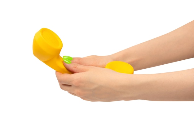 흰색 배경 복사 공간에 고립된 녹색 손톱을 가진 여자 손에 있는 노란색 휴대폰