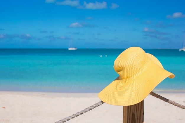 Yellow hat on the beach fence at caribbean island