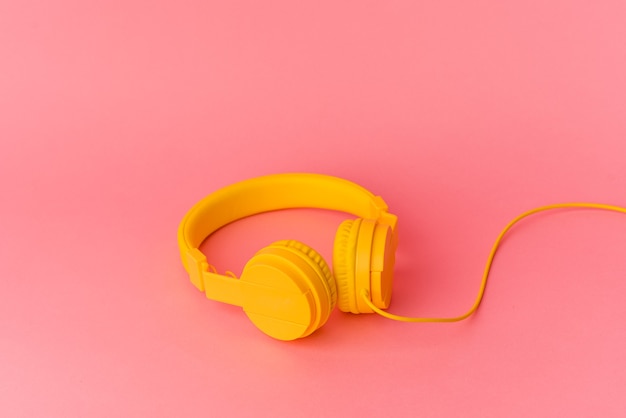 Yellow headphones isolated on pink background