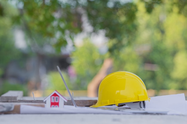 Желтый шлем безопасности каски при строительстве площадки для недвижимости