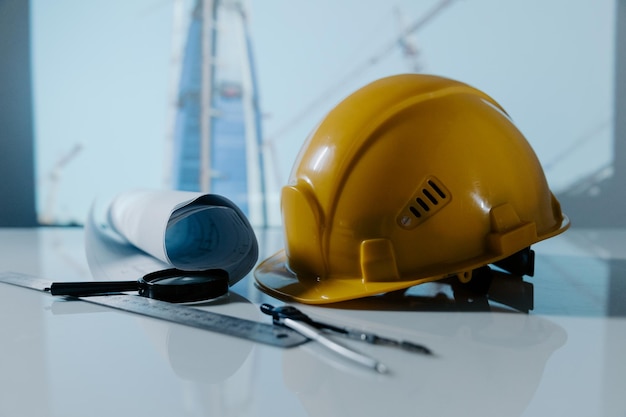 Cappello da casco giallo e progetti di costruzione di un cantiere su un tavolo concetto di costruzione