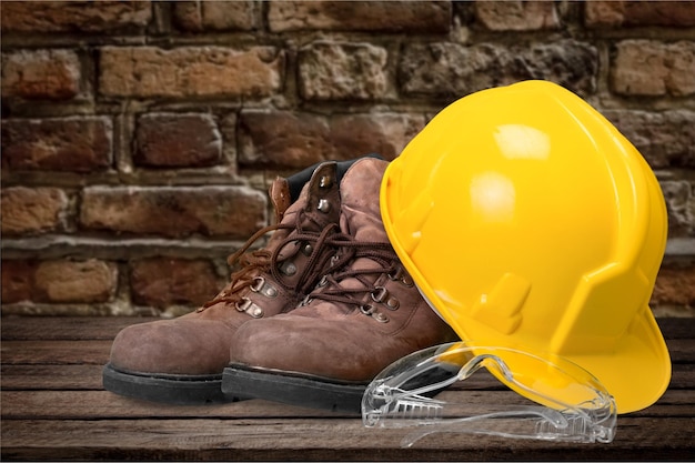 Yellow helmet with equipment on wall background