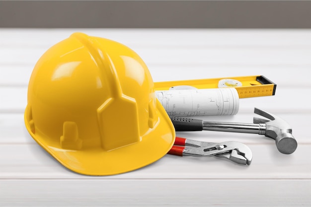 yellow helmet with equipment on wooden table background