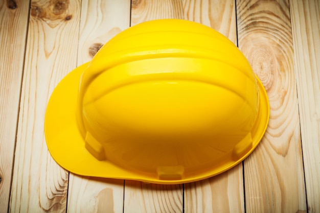 An yellow helmet on wood boards