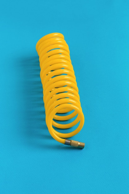 Yellow hose for connecting to a car compressor on a blue background