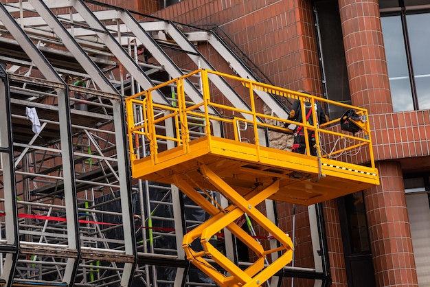 Yellow hydraulic lifting platform with bucket cabin on a telescopic lift