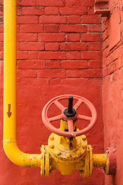 Foto gasdotto industriale giallo con gomito e valvola di isolamento con maniglia rotante