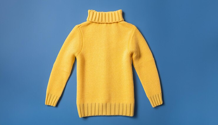 Photo yellow jacket and warm sweater and hat on blue background set of children's clothes