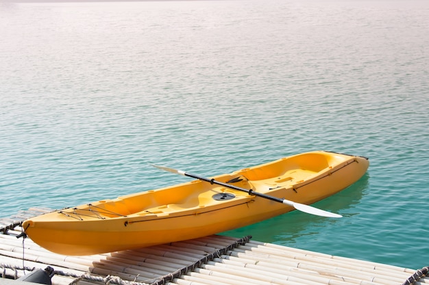 Yellow kayak boat park at forest lake pier.