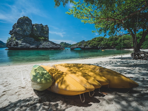 Photo yellow kayaks on white sand beach of breathtaking rock formation island mu koh ang thong thailand