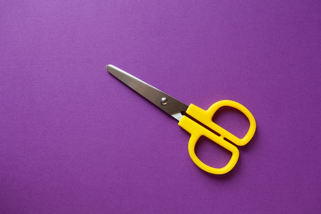 Yellow kid's stationery right-handed scissors on purple 